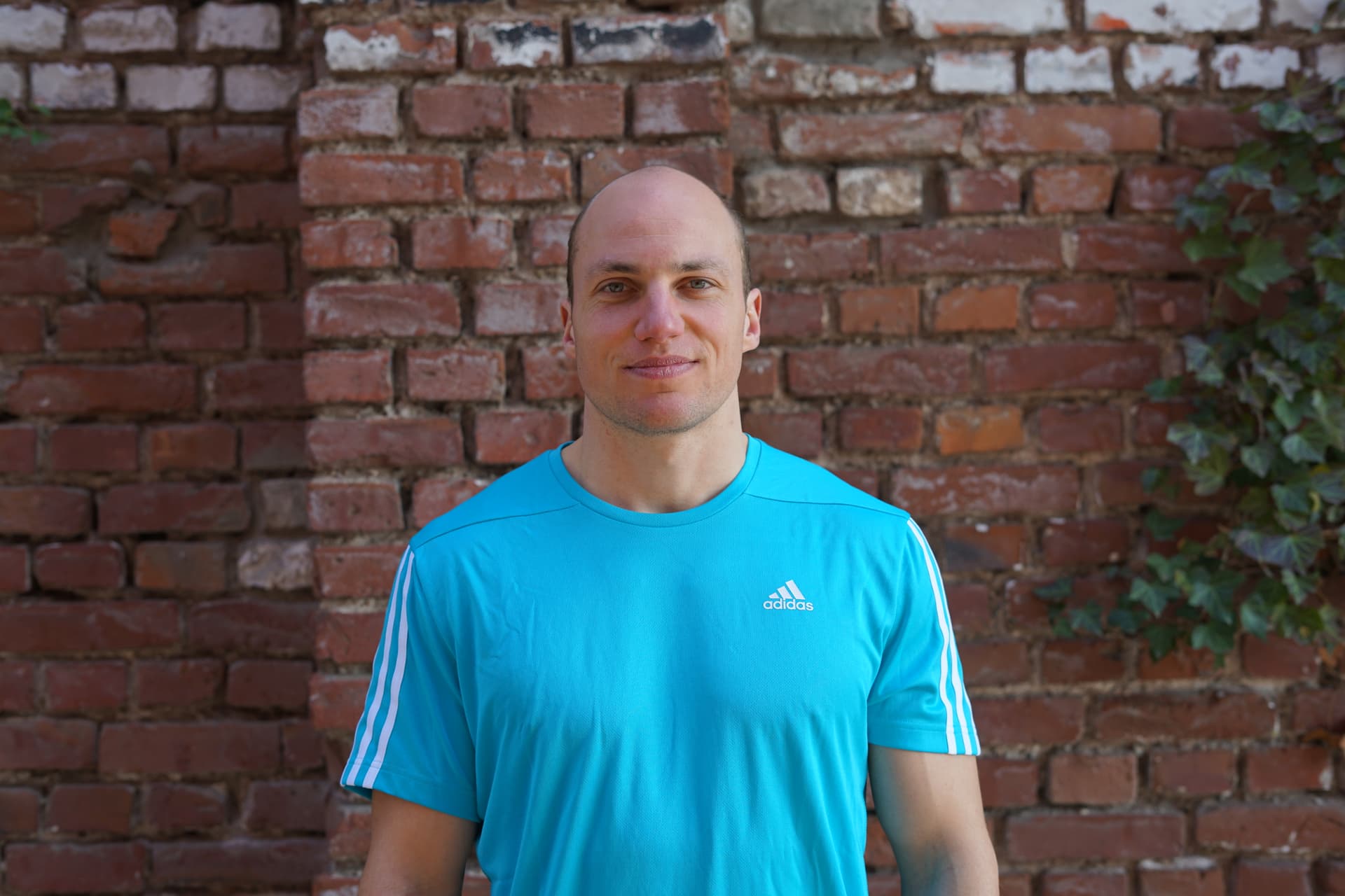 Fitness Trainer Malte steht vor einer Wand