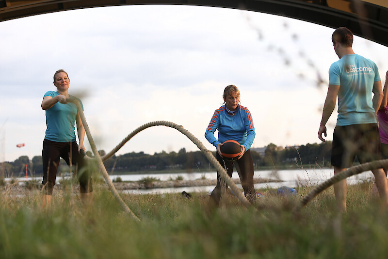 OutdoorFitness Düsseldorf mit funktionellem Ganzkörpertraining am Rhein, Gruppe nutzt Battle Ropes und Medizinball für Kraft und Ausdauer.