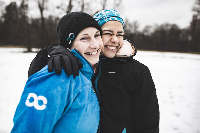 Outdoor Fitness München: Zwei Teilnehmerinnen lachen nach dem Training im Schnee.