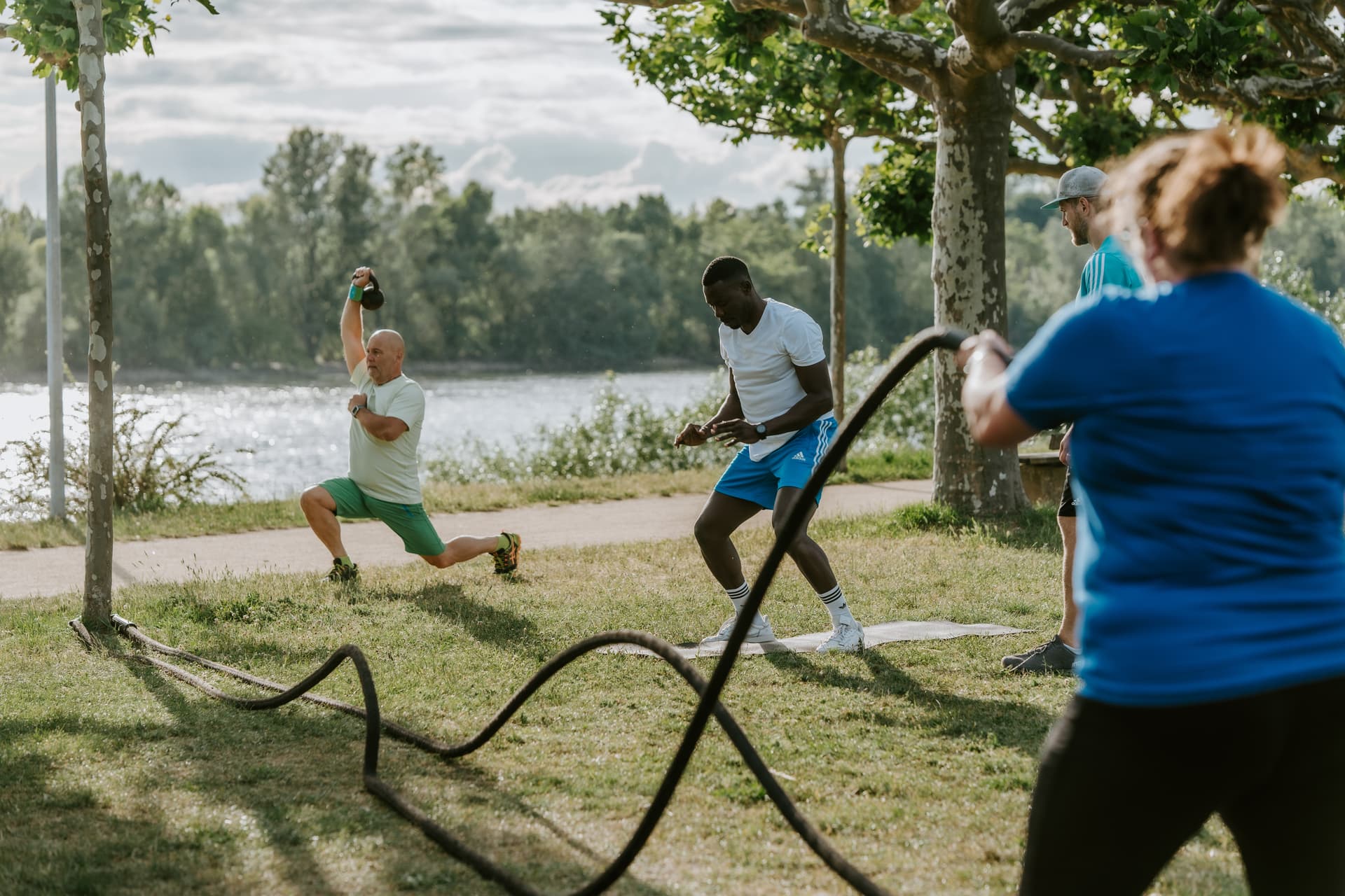 Gruppe beim Ganzkörper-Training im Freien, begleitet von einem Trainer