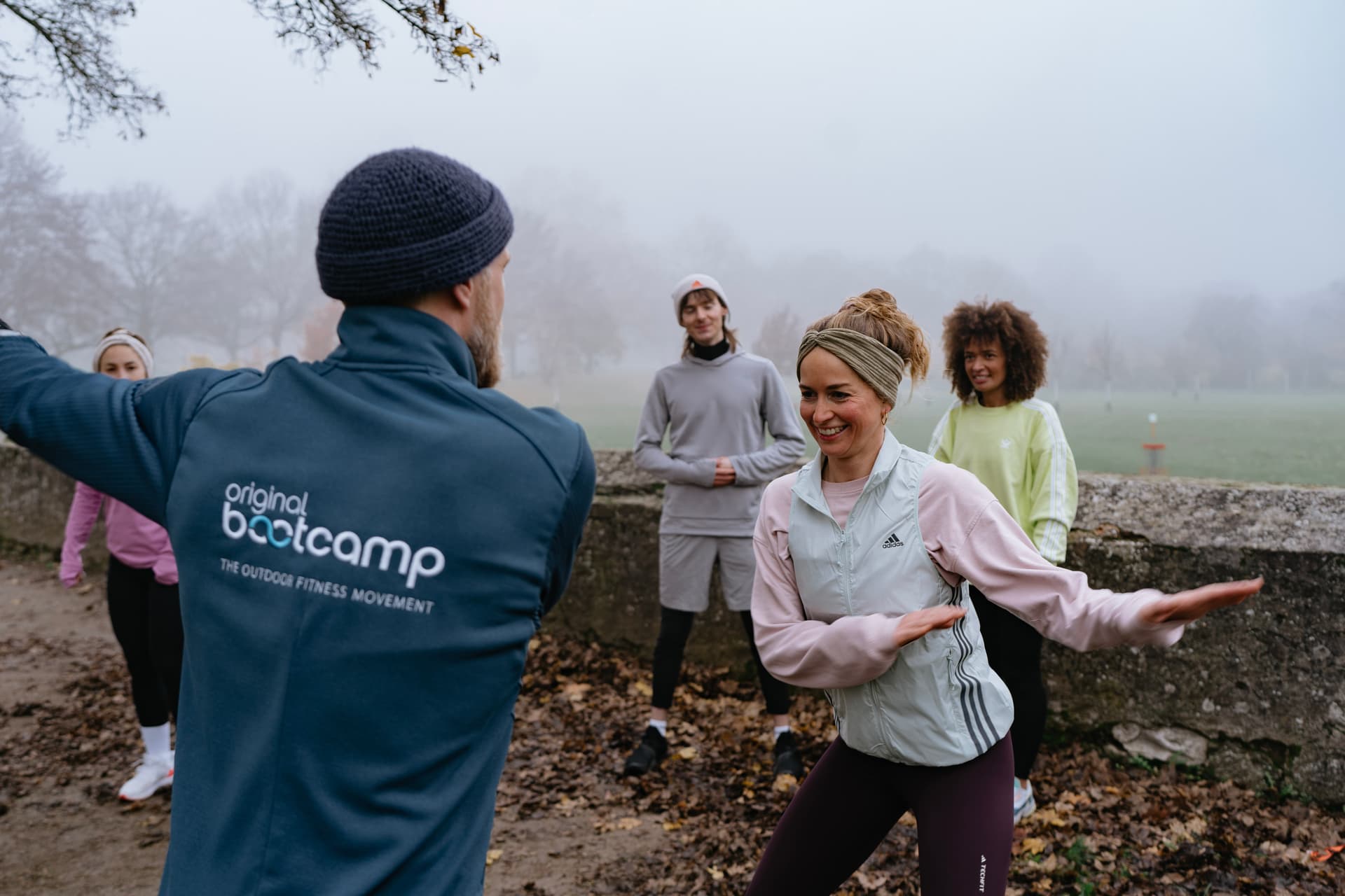 Ein Personal Trainer zeigt einer Teilnehmerin wie die nächste Übung funktioniert