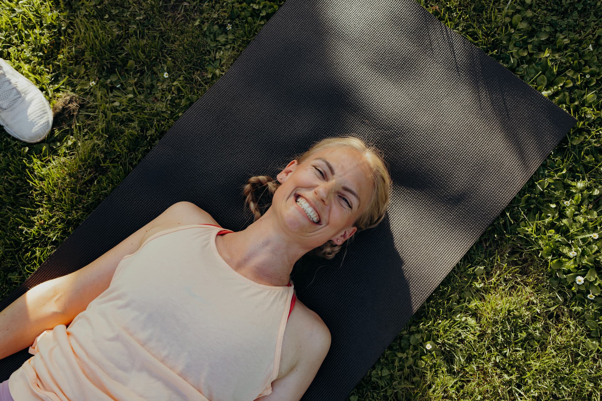 Frau mit Lachen auf einer Sportmatte