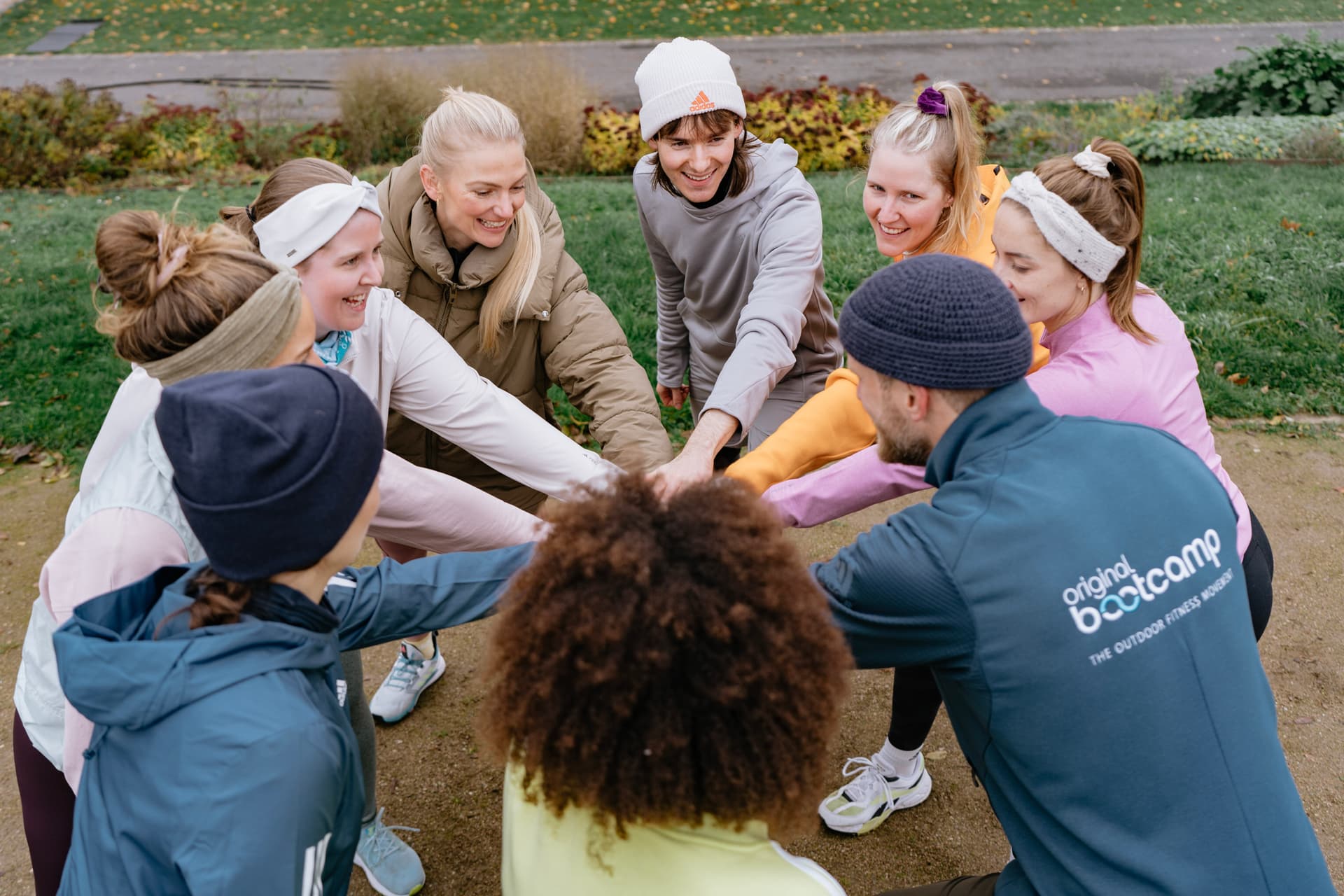 Ein Bootcamp Team steht im Kreis und legt die Hände aufeinander