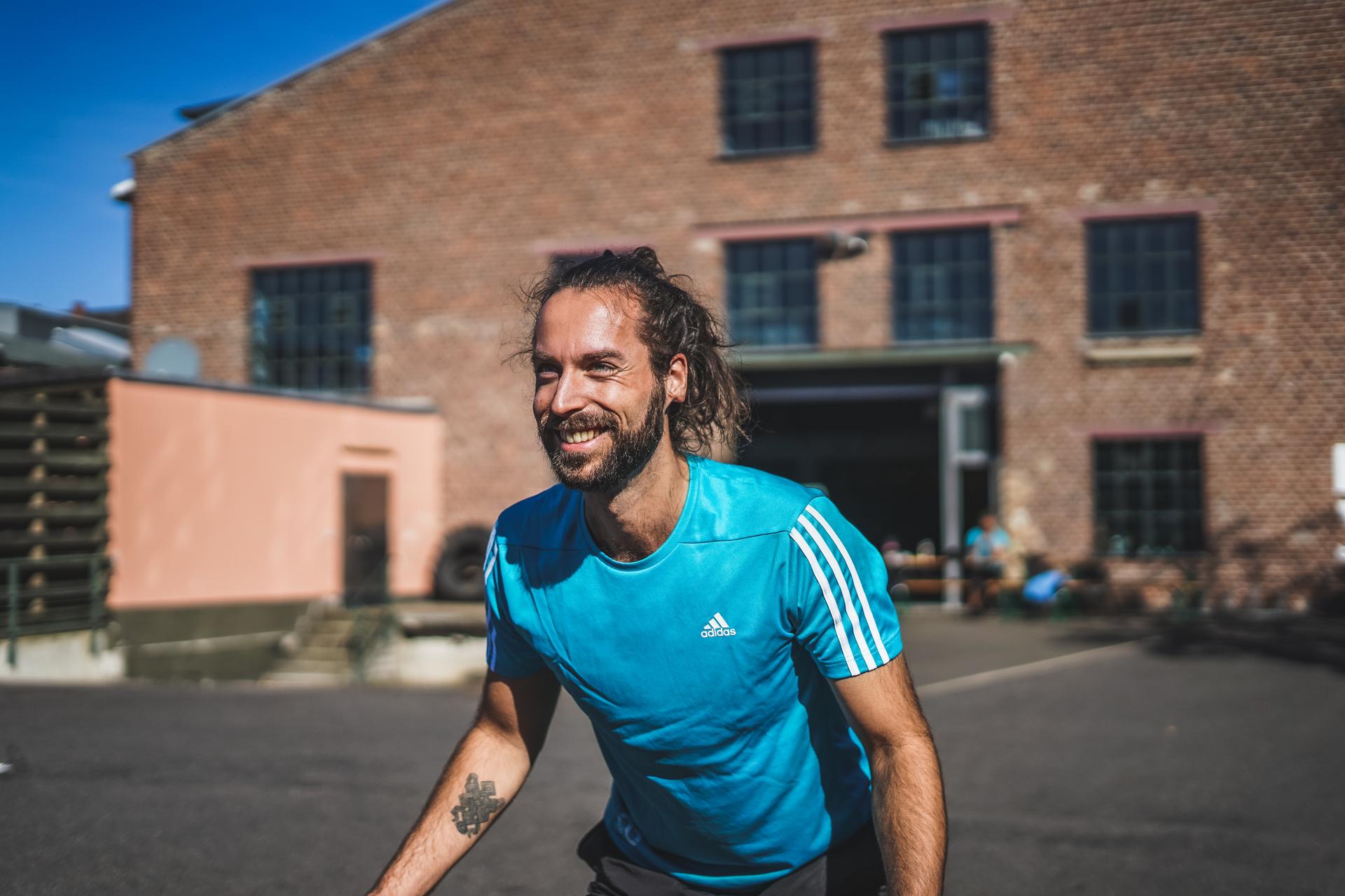 Trainer Maximilian Krüger im blauen Shirt in der Sonne