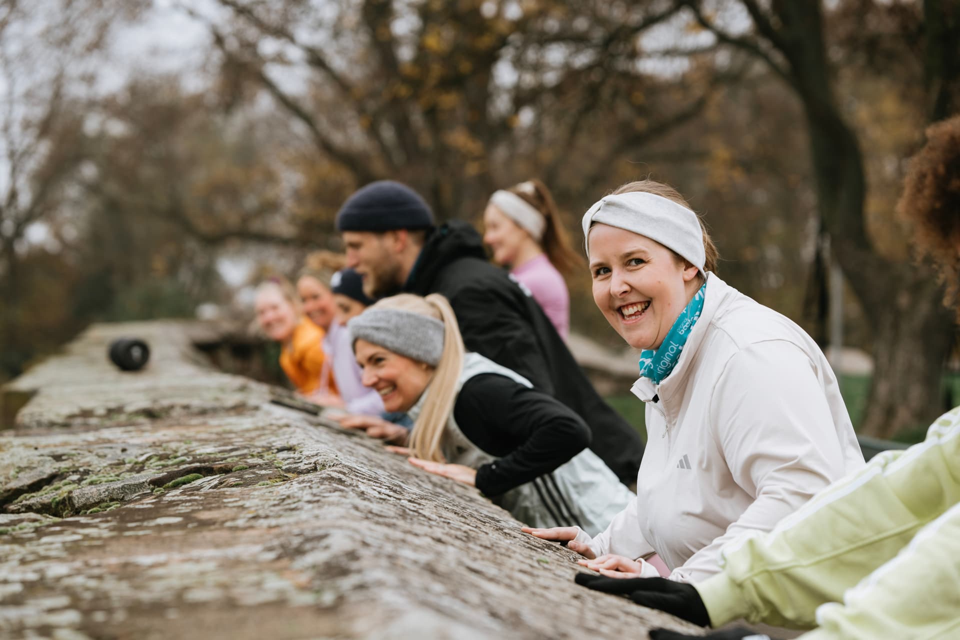 Eine Gruppe trainiert ihre Armkraft im Outdoor Fitness Bootcamp