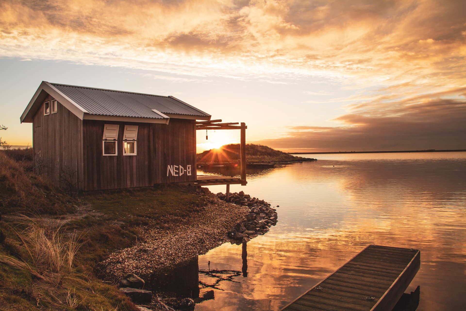 Die Sonne geht unter hinter den Beach Bungalows in den Niederlanden