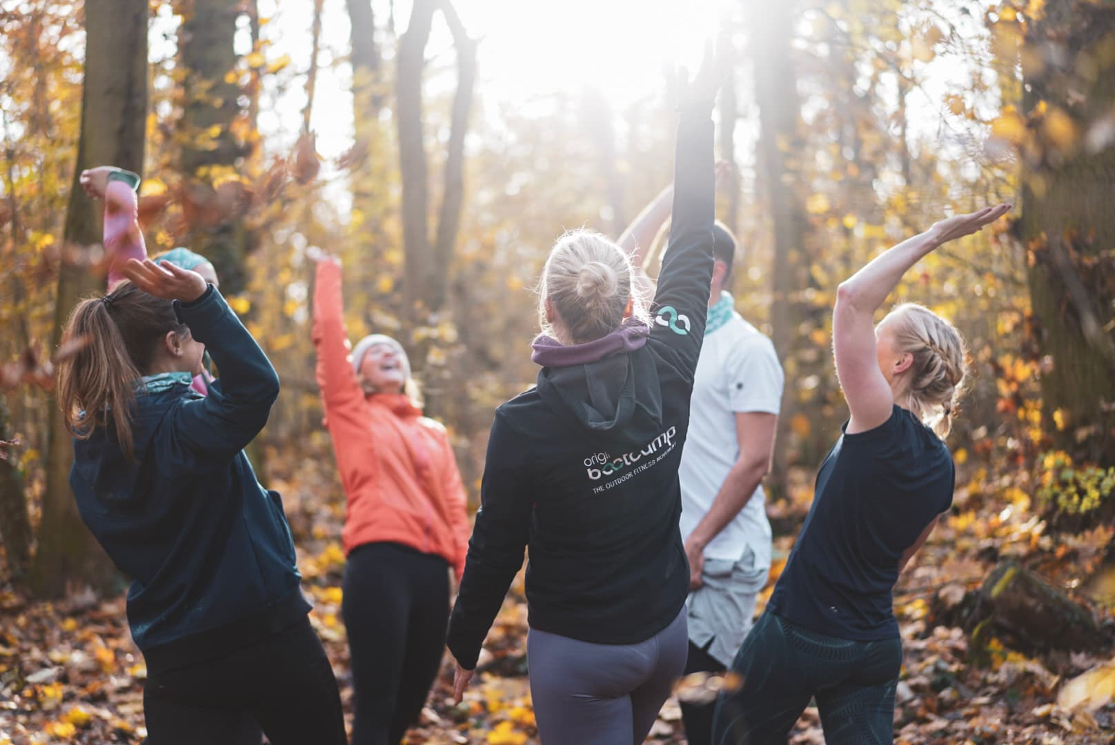 Eine Outdoor Trainingsgruppe feiert gemeinsam das vollendete Training