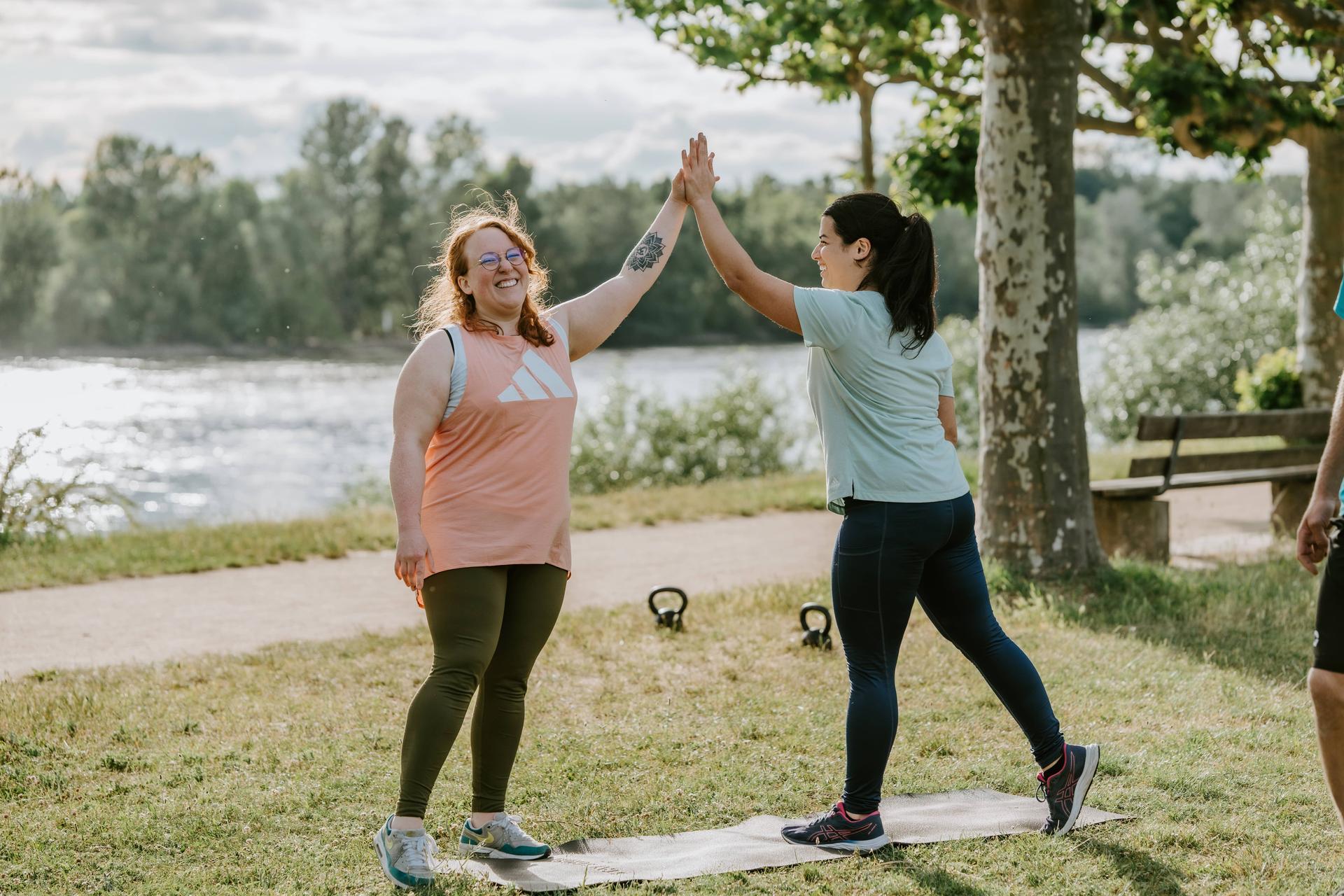 Zwei Frauen lachen gemeinsam im Outdoor Fitness Bootcamp