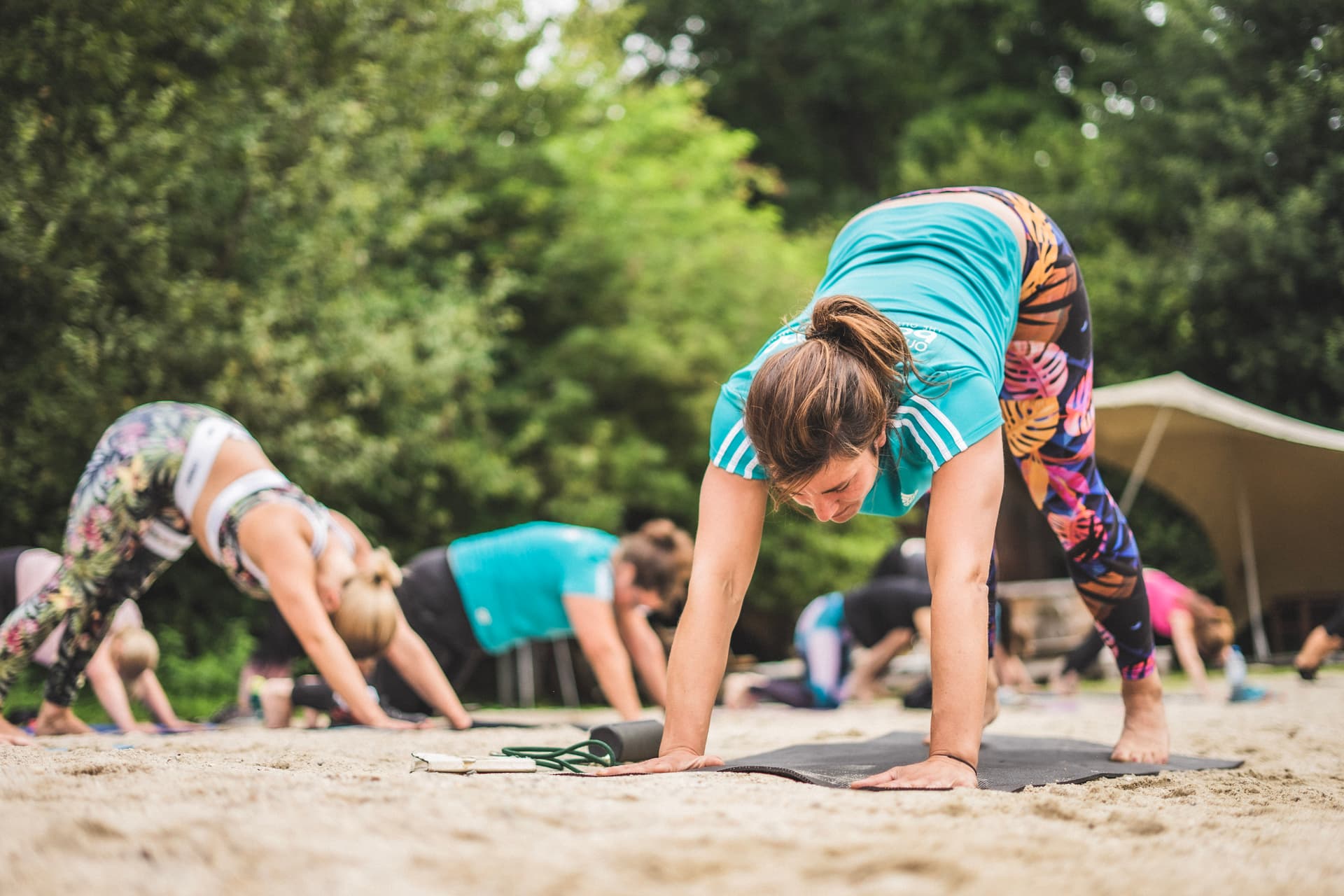 Morgendliche Stretching Einheit im Sand.