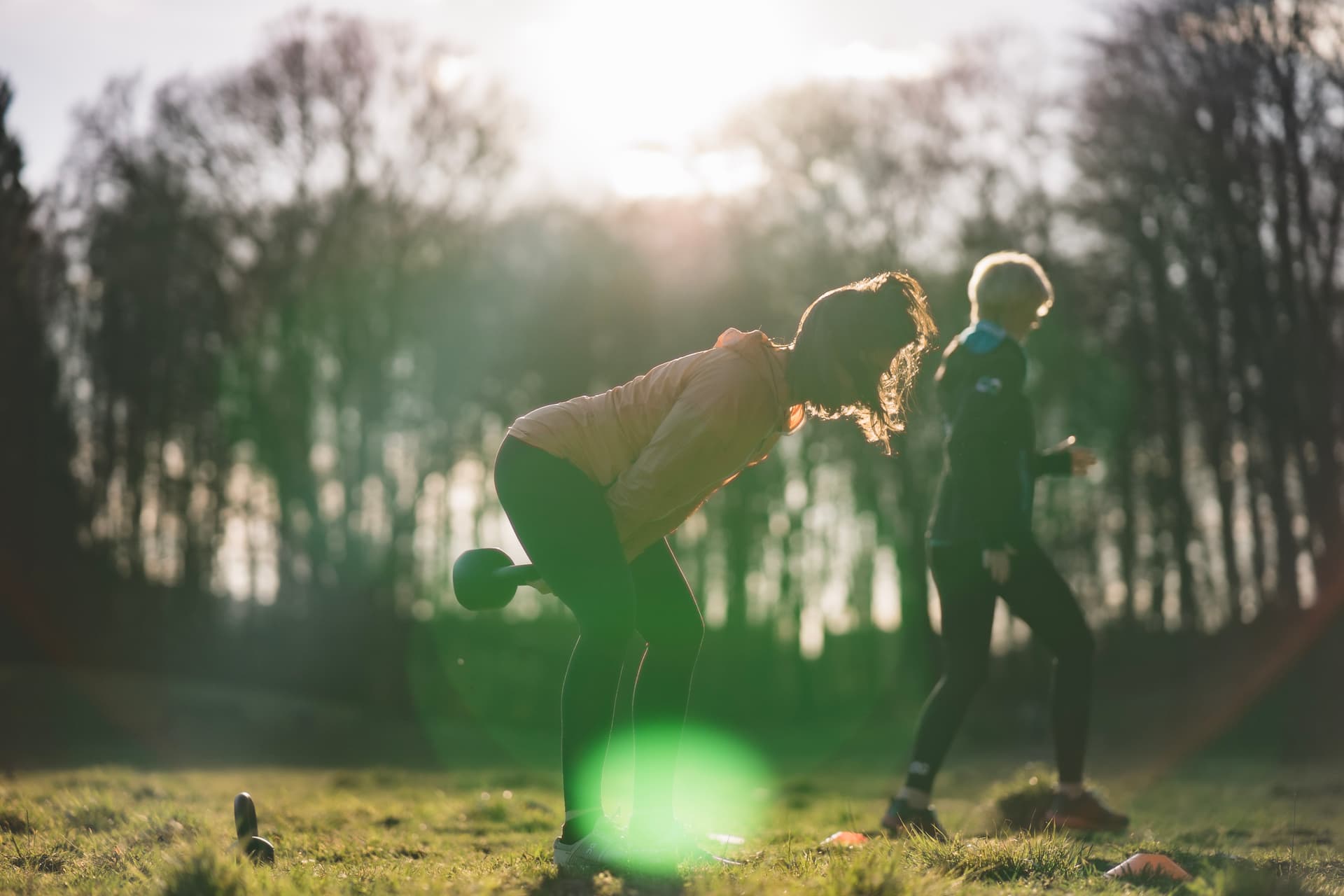 Eine Frau trainiert mit Kettlebells bei Original Bootcamp Outdoor Movement