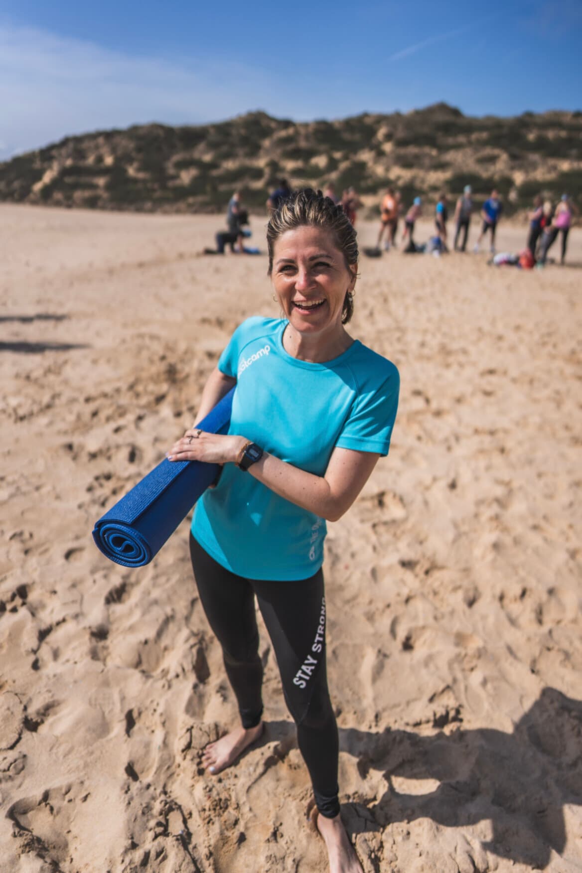 Frau steht im Fitnessurlaub am Strand