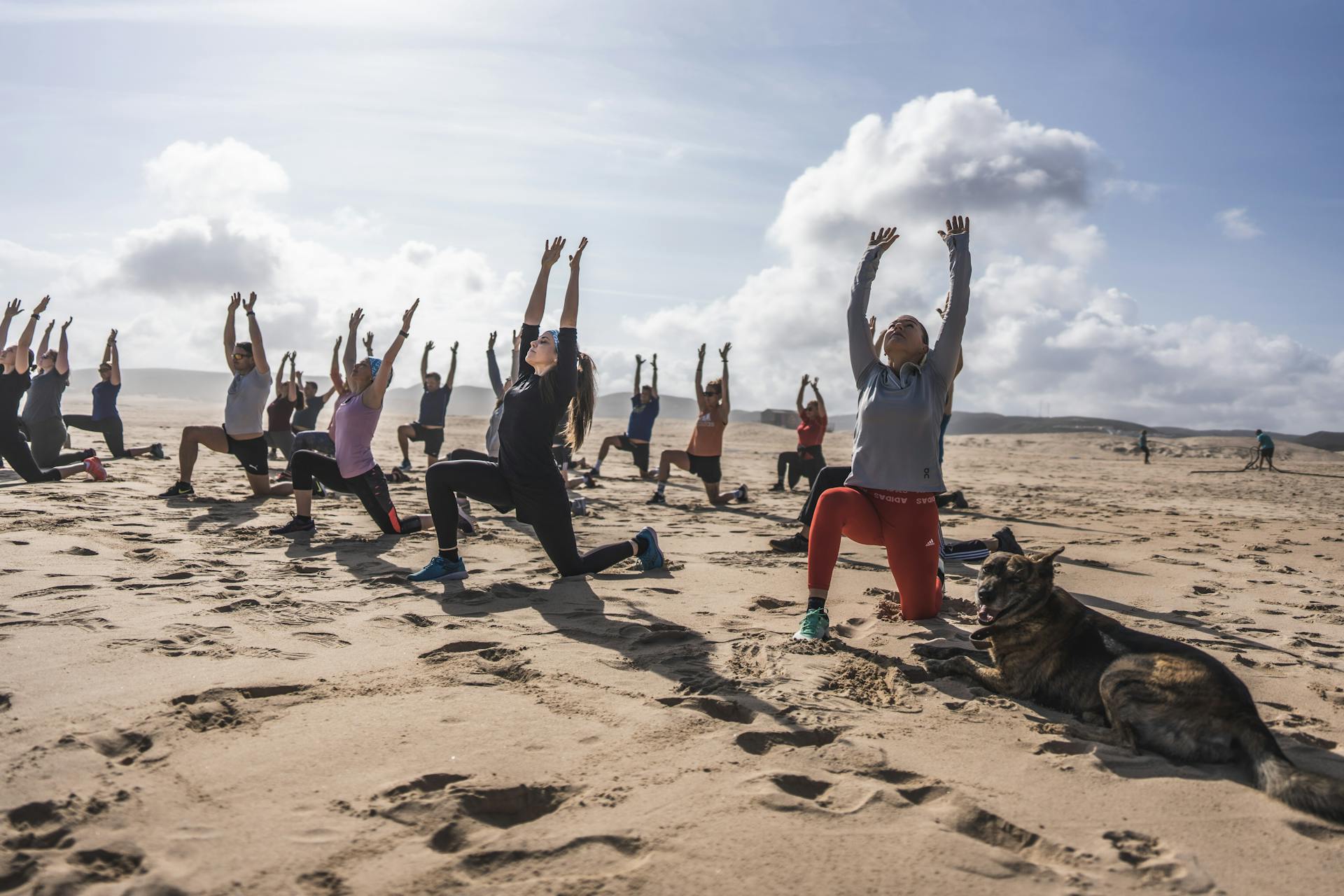 Eine Fitness Retreat Gruppe trainiert bei sonnigem Wetter am Strand
